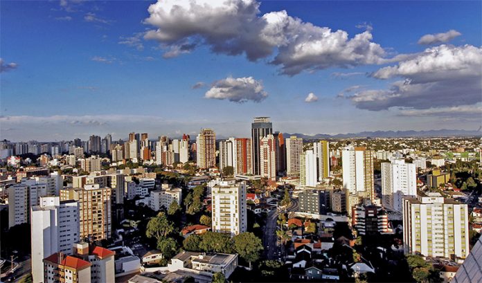 Vista panorâmica da cidade de São Caetano do Sul. O céu está com poucas nuvens, o dia está ensolarado e é possível ver prédios e casas se expandindo até o horizonte da cidade.