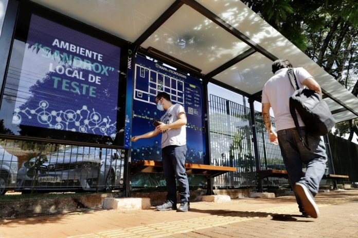 Fotografia de usuário em ponto de ônibus com tecnologia inteligente